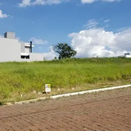 Vista de um campo gramado sob um céu azul.