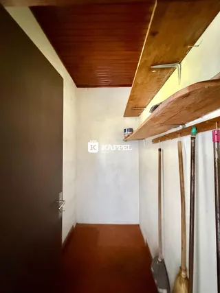 Hall de entrada com piso de madeira e forro de madeira exposto.
