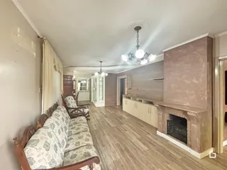 Imagem de uma sala de estar com piso de madeira e lareira.