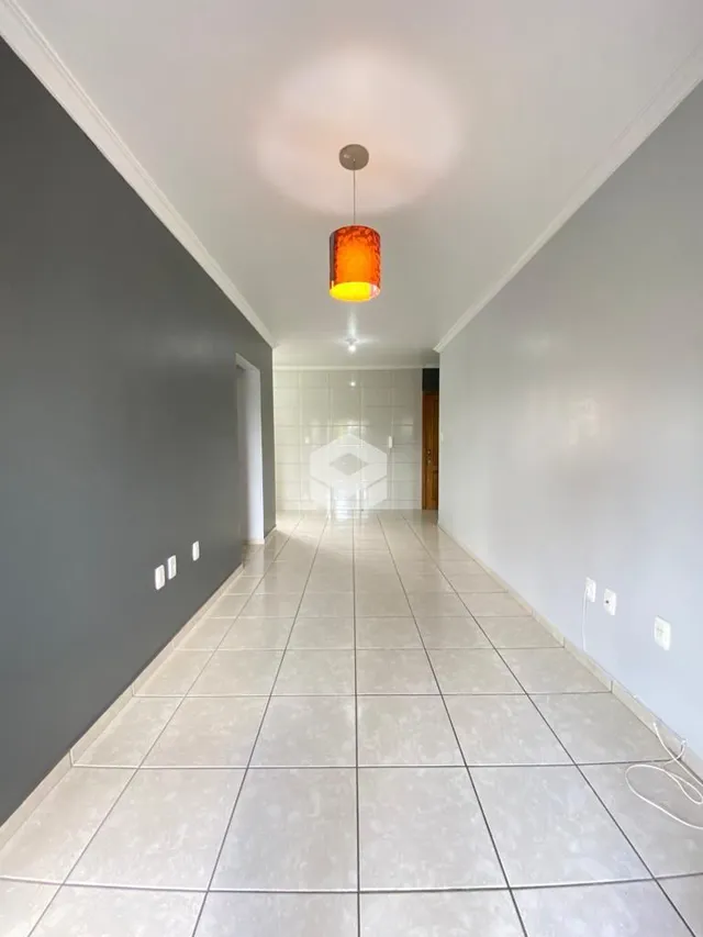 Corredor interno com piso de cerâmica claro e paredes cinzas.