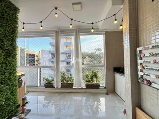 Sala de estar com grandes janelas que oferecem uma vista externa.