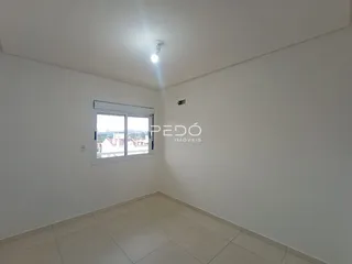Foto de um cômodo interno com paredes brancas e piso claro.