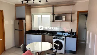 Foto interna de uma cozinha com armários e eletrodomésticos modernos.