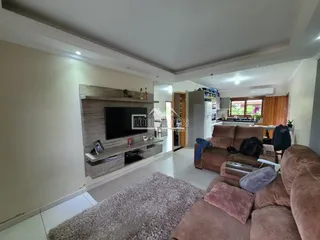 Sala de estar com lareira e sofá marrom em um imóvel no Brasil.