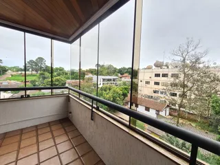 Vista de um terraço com piso de cerâmica e grade de segurança.