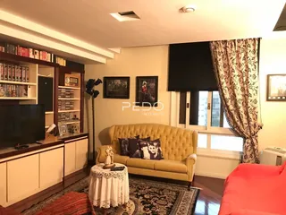 Sala de estar com sofá e estantes de madeira em um imóvel no Brasil.