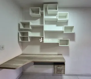 Parede com prateleiras brancas e um banco de madeira em um ambiente interno.