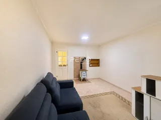 Sala de estar com sofá e piso de cerâmica em um imóvel no Brasil.