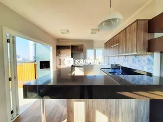 Cozinha moderna com bancada escura e armários de madeira.
