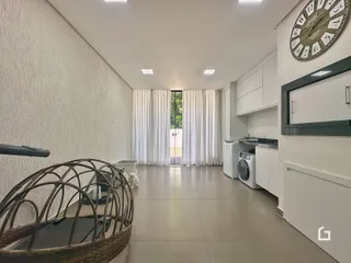 Interior de uma sala de estar com piso claro e paredes brancas.