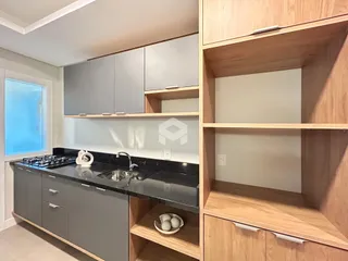 Cozinha moderna com armários cinzas e bancada preta.