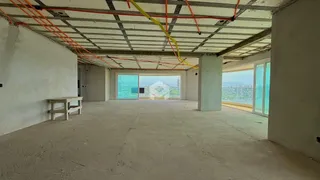 Foto de um espaço interno com estrutura de teto exposta e piso de concreto.