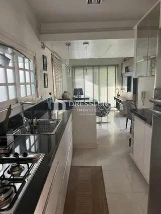 Vista da cozinha moderna com piso de cerâmica clara.