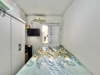 Quarto com cama e armários brancos em um imóvel.