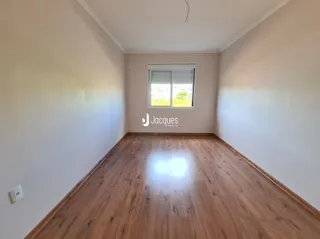 Sala de estar com piso de madeira e janela iluminada.