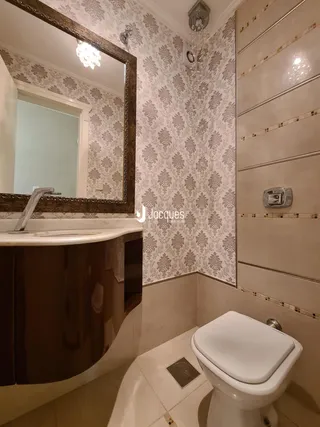 Foto de um banheiro com revestimento de parede e louças sanitárias.