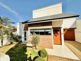 Fachada de uma casa em Lajeado, Brasil, com jardim frontal e porta de madeira.