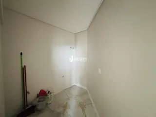Hall de entrada com paredes brancas e piso claro.