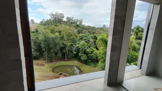 Vista exuberante de vegetação e um pequeno lago em uma propriedade em Lajeado.