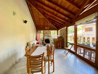 Sala de jantar com teto de madeira e piso de cerâmica.