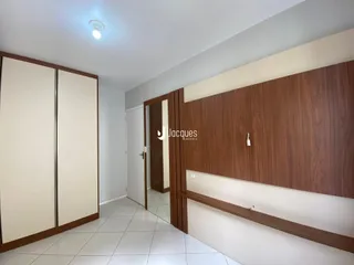 Hall de entrada com revestimento de madeira e piso cerâmico claro.