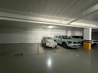 Área de estacionamento coberta com veículos estacionados.