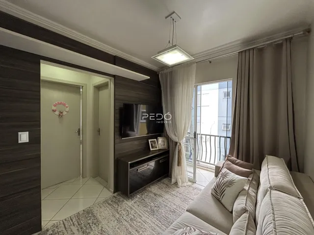 Sala de estar com sofá e televisão em um imóvel no Brasil.