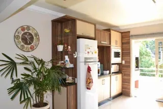 Foto de uma cozinha com armários de madeira e geladeira.