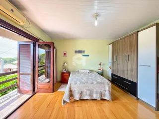 Quarto com piso de madeira e guarda-roupa no interior de uma residência.