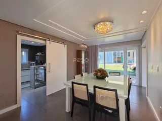 Sala de jantar com portas de vidro que dão acesso a uma área externa.