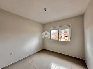 Foto de um ambiente interno vazio com paredes brancas e piso de cerâmica.