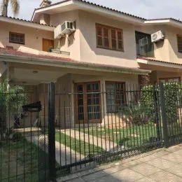 Fachada de uma residência em Lajeado, Brasil, com cerca e vegetação.