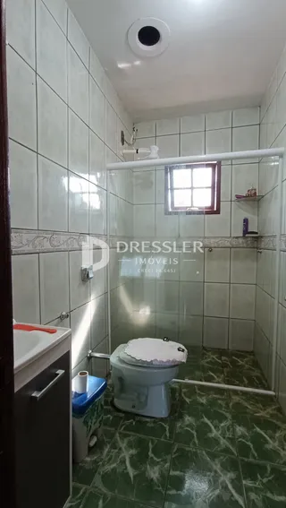 Foto de um banheiro com piso de azulejo verde e box de vidro.