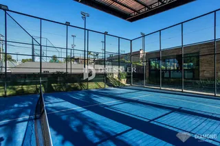 Uma quadra esportiva externa azul cercada por uma cerca de tela.