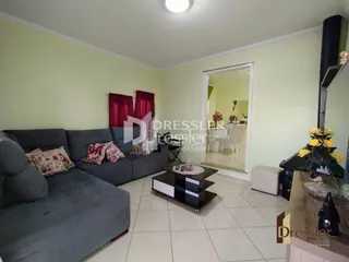 Sala de estar com sofá cinza e paredes verdes.