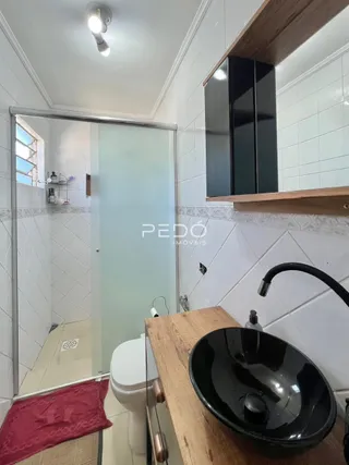 Foto de um banheiro com revestimento branco e porta de vidro.