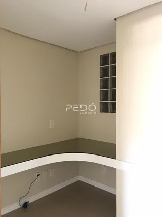 Vista interna de um cômodo com paredes brancas e uma janela.