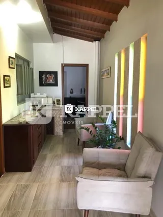 Uma foto interna mostra um ambiente com piso de madeira clara e estrutura de teto de madeira.