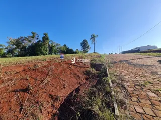 Paisagem de terra e vegetação em uma área aberta sob um céu azul.