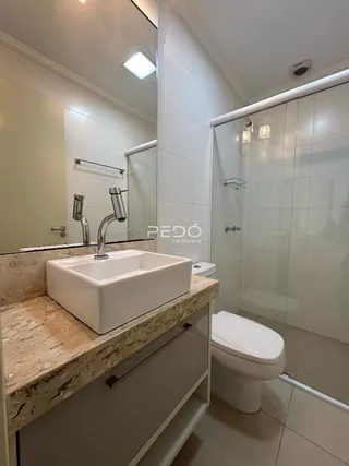 O interior de um banheiro com bancada e box de vidro.