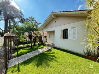 Fachada de uma casa em Lajeado, Brasil com jardim gramado e cerca.