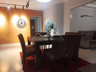 Sala de jantar com mesas e cadeiras de madeira escura em ambiente interno.