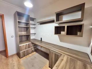 Interior com estantes e móveis de madeira em um ambiente residencial.