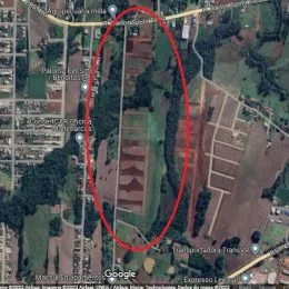 Vista aérea de uma área de terreno com vegetação e estradas.