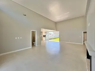 Vista interna de um ambiente amplo com paredes brancas e piso claro.