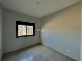 Vista interna de uma sala com piso de cerâmica e janela grande.