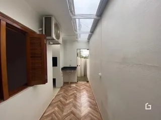 Corredor interno com piso de madeira e teto inclinado.