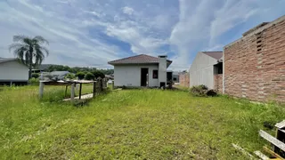 Foto da fachada de uma casa com jardim gramado e muro de tijolos.