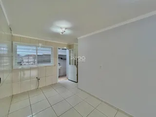 Interior de um corredor com piso de cerâmica e paredes brancas.