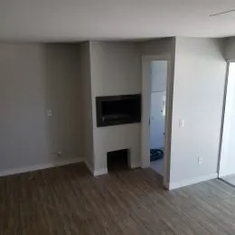 Ambiente interno com piso de madeira e paredes claras.